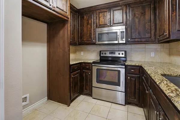 a kitchen with stainless steel appliances granite countertop a stove and a microwave