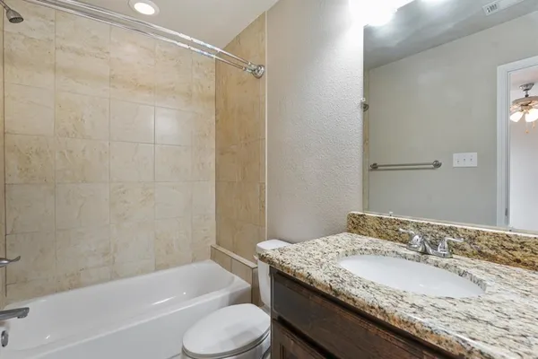 a bathroom with a granite countertop sink toilet and shower
