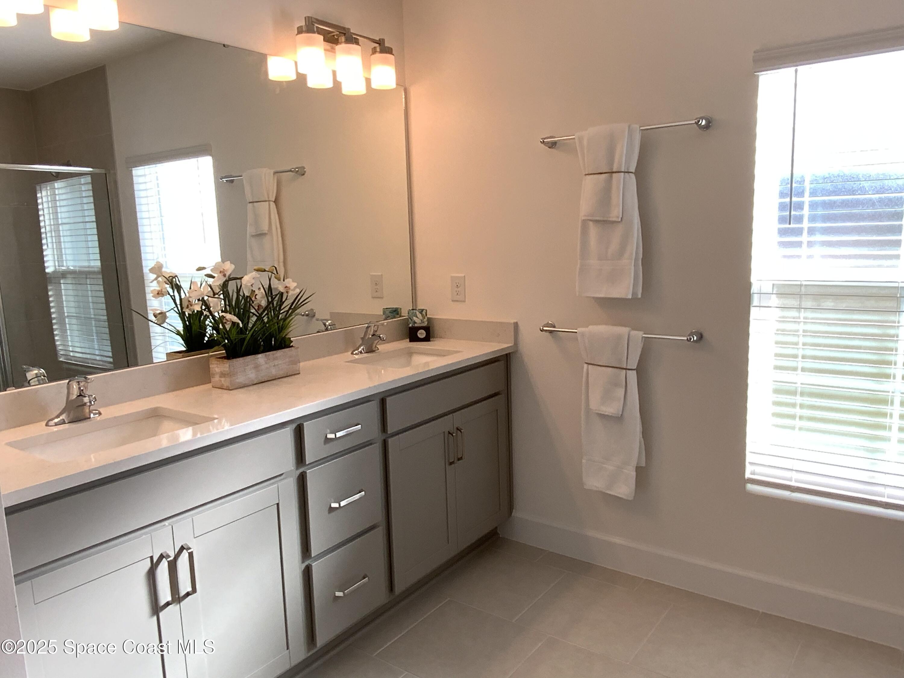 1787 Fallon Boulevard Northeast Palm Bay, FL 32907 - Photo 14 of 18 a bathroom with a double vanity sink and a mirror