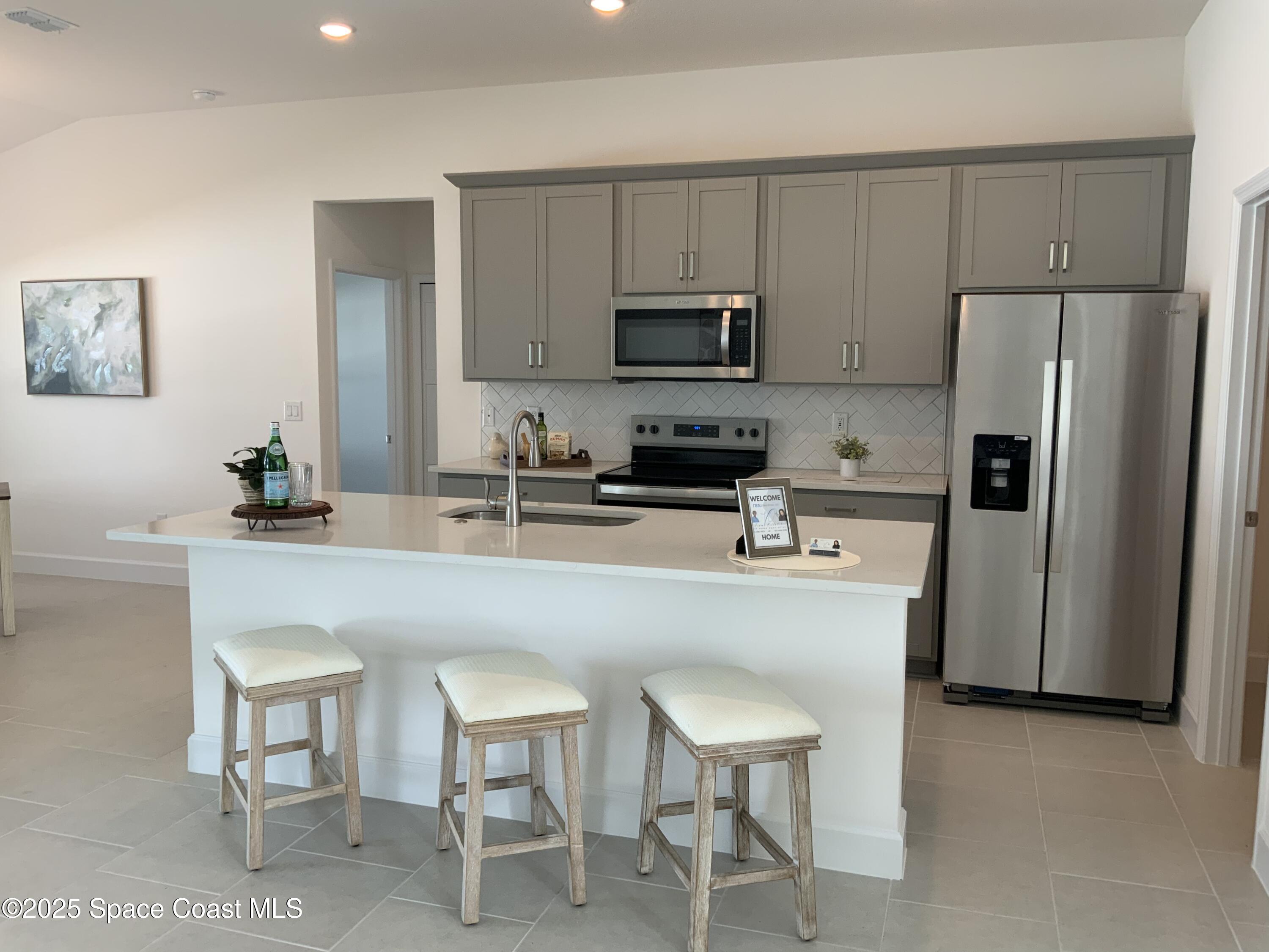 1787 Fallon Boulevard Northeast Palm Bay, FL 32907 - Photo 6 of 18 a kitchen with stainless steel appliances a refrigerator and a stove top oven