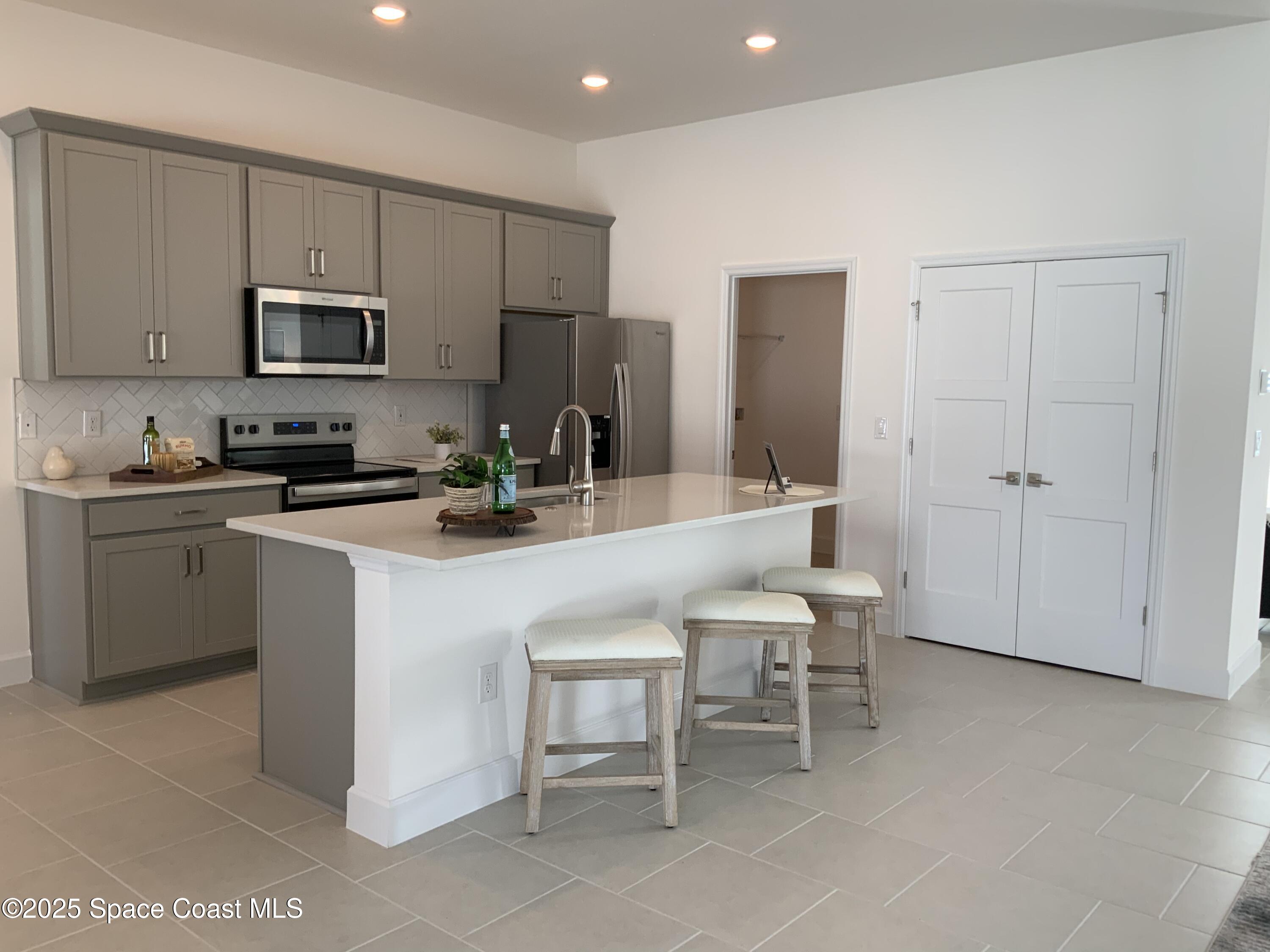 1787 Fallon Boulevard Northeast Palm Bay, FL 32907 - Photo 7 of 18 a kitchen with a sink cabinets and stainless steel appliances
