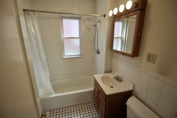 a bathroom with a sink toilet vanity and bathtub