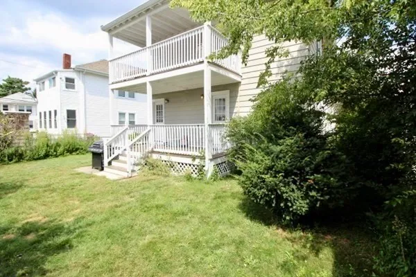 a view of a house with backyard and sitting area
