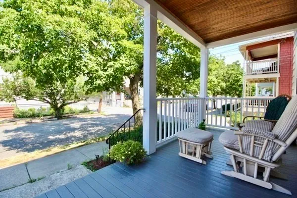 a view of a porch with furniture and a yard