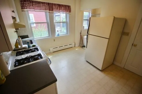 a kitchen with a refrigerator a stove and a window