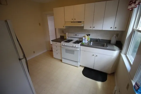 a kitchen with a sink a stove and cabinets