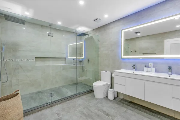 a bathroom with a double vanity sink mirror and toilet