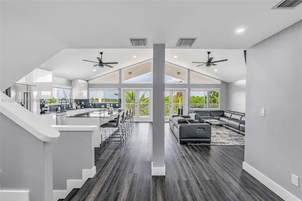 a view of a living room and kitchen with furniture large window