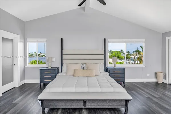 a large white bed sitting in a bedroom next to a window