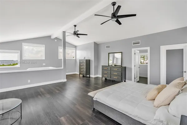 a bed room with a bed a chandelier and a window