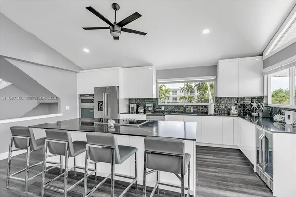 a kitchen with stainless steel appliances a dining table chairs and a window