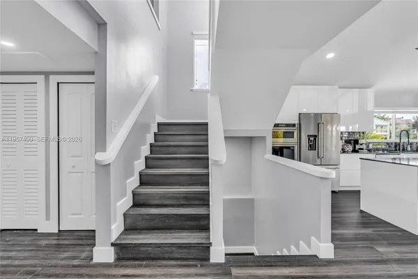a view of kitchen with stainless steel appliances refrigerator and cabinets