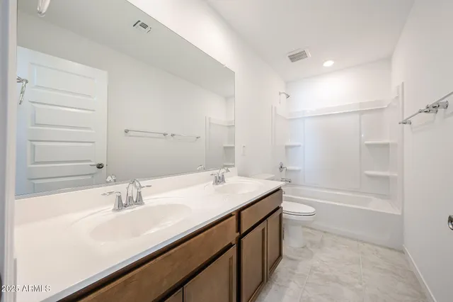 a bathroom with a sink double vanity granite tub shower and a mirror