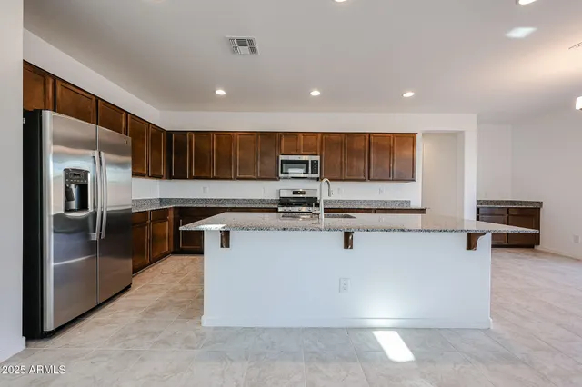 a kitchen with stainless steel appliances granite countertop a stove a sink and a refrigerator