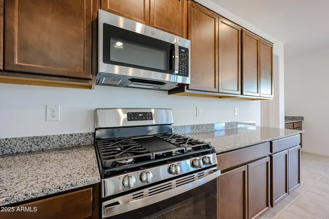 a kitchen with stainless steel appliances granite countertop a stove and a microwave