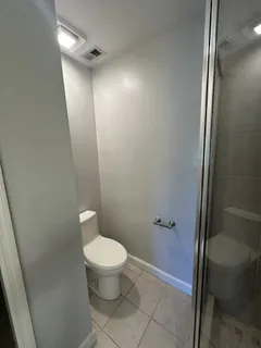 a bathroom with a granite countertop toilet and a shower