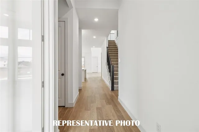 a view of a hallway with wooden floor and staircase