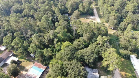 an aerial view of a residential houses with yard