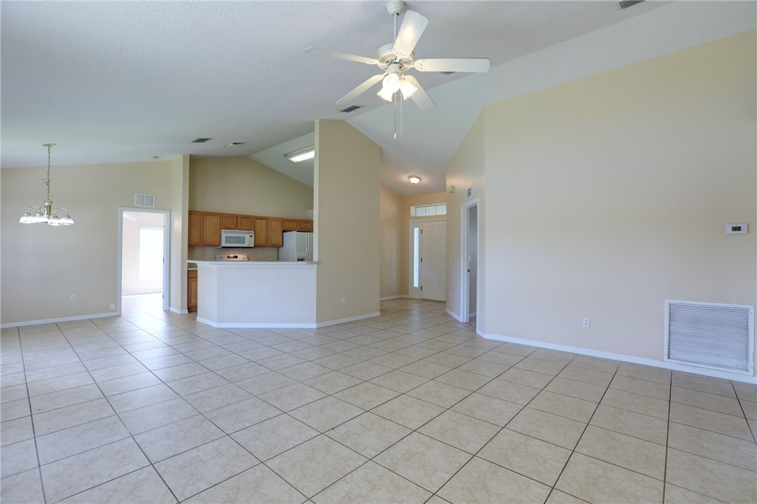 113 Drake Way Sebastian, FL 32958 - Photo 12 of 36 an empty room with a kitchen and a chandelier fan