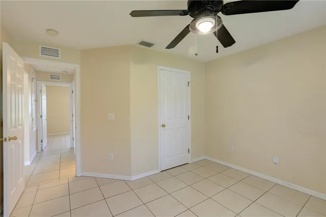 an empty room with a ceiling fan and carpet