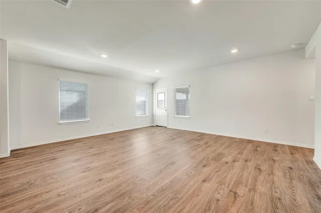 a kitchen with stainless steel appliances granite countertop a stove top oven a sink dishwasher and a refrigerator with wooden cabinets