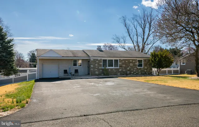 a front view of house with yard and trees in the background