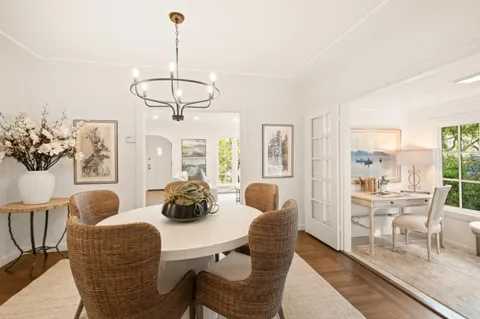 a dining room with furniture a chandelier and window