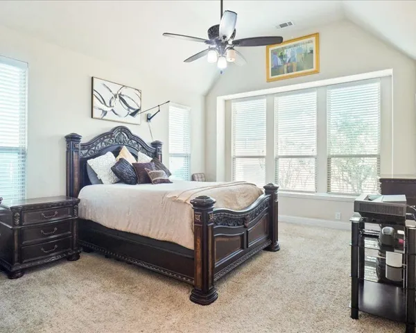 a bedroom with a bed dresser and a window