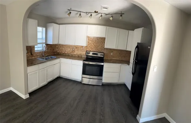a kitchen with stainless steel appliances a stove a sink and a refrigerator