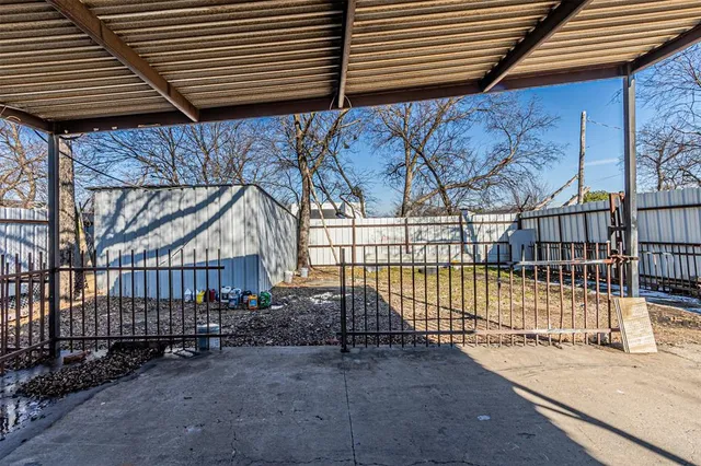 a view of a backyard with a small deck and a barbeque grill with floor to ceiling window