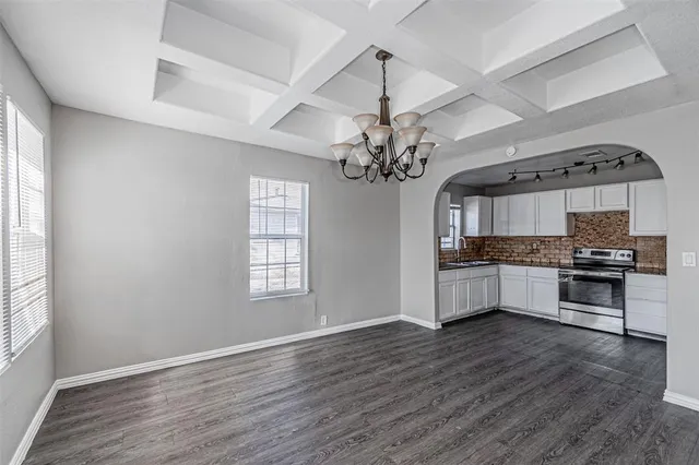 a large kitchen with a wooden floor and stainless steel appliances