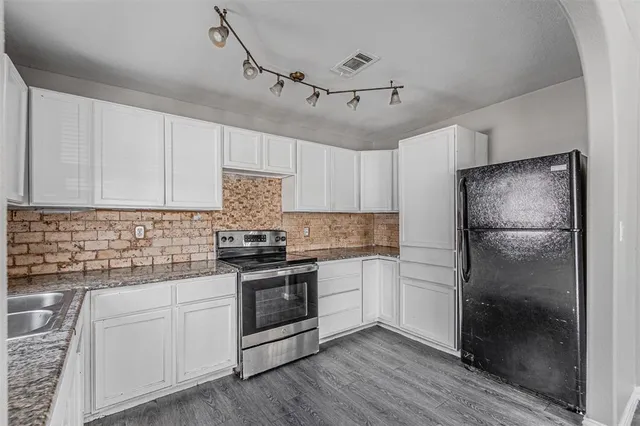 a kitchen with a refrigerator sink and cabinets