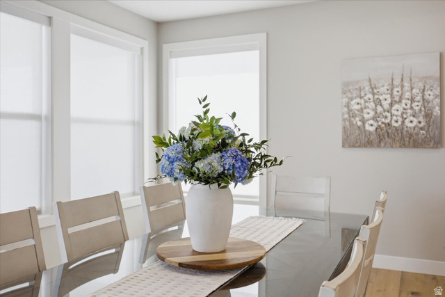 21 Pier Place Tooele, UT 84074 - Photo 14 of 112 Dining area featuring multiple windows with roller shades, light wood-finish flooring, and a neutral wall color