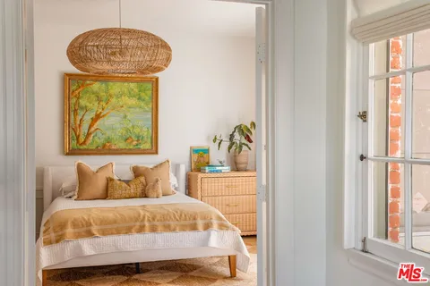 a bedroom with a bed and a painting on the wall