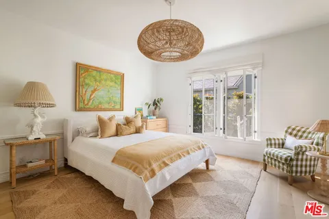 a bedroom with a bed and a painting on the wall