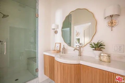 a bathroom with a sink a potted plant and a mirror