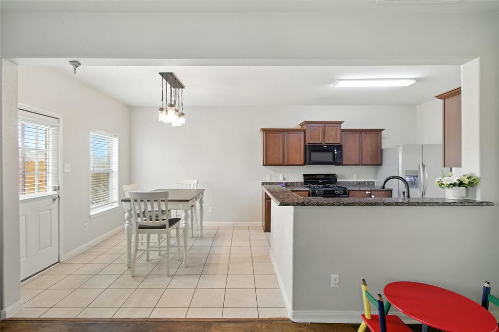 1100 Port Way Crowley, TX 76036 - Photo 14 of 31 a kitchen with stainless steel appliances a dining table chairs and granite counter tops