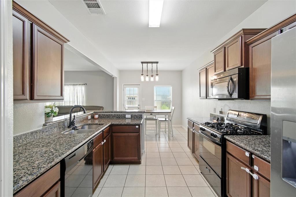1100 Port Way Crowley, TX 76036 - Photo 20 of 31 a kitchen with stainless steel appliances granite countertop a sink stove microwave and refrigerator