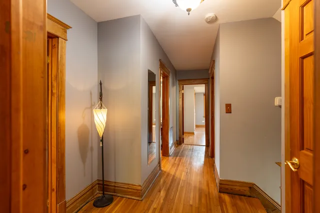 a view of a hallway with wooden floor and staircase