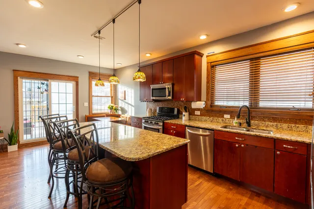 a kitchen with granite countertop sink stove dining table and chairs