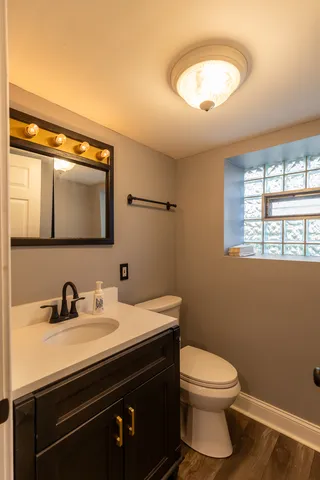a bathroom with a toilet a sink and mirror