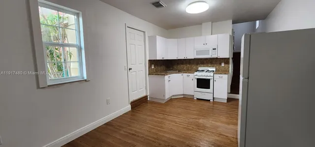 a view of kitchen with stainless steel appliances granite countertop a stove and a refrigerator