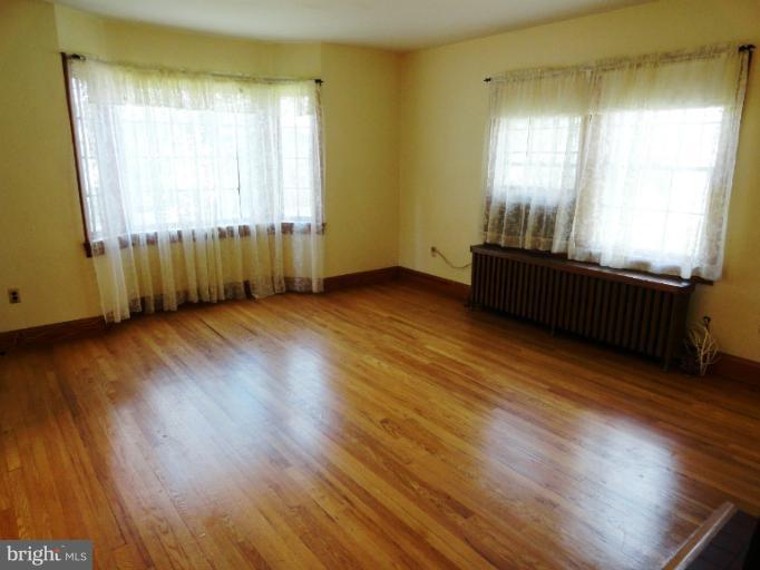 411 Forest View Road Linthicum Heights, MD 21090 - Photo 22 of 30 a view of an empty room with wooden floor and a window