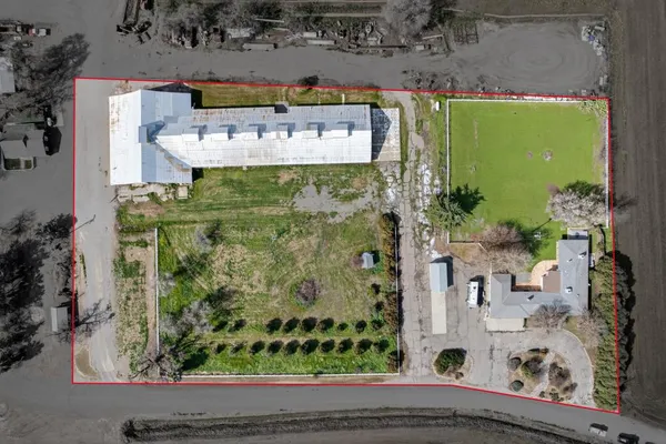 a front view of a house with a garden and trees