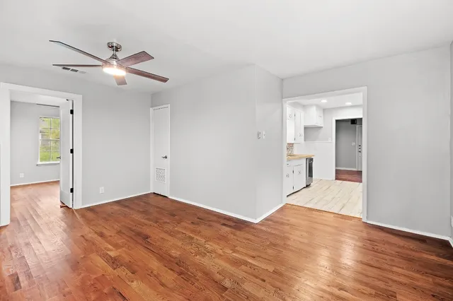 a view of empty room with wooden floor