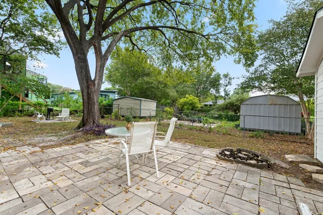 a backyard of a house with table and chairs