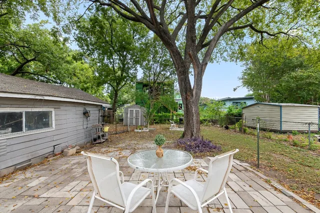 a backyard of a house with table and chairs