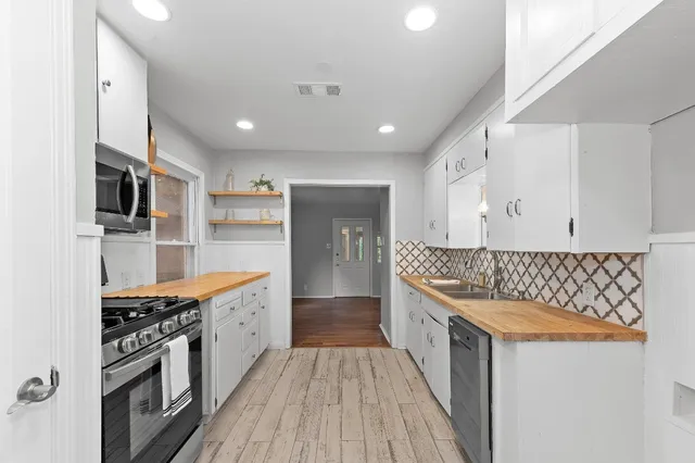 a kitchen with stainless steel appliances granite countertop a stove and a sink