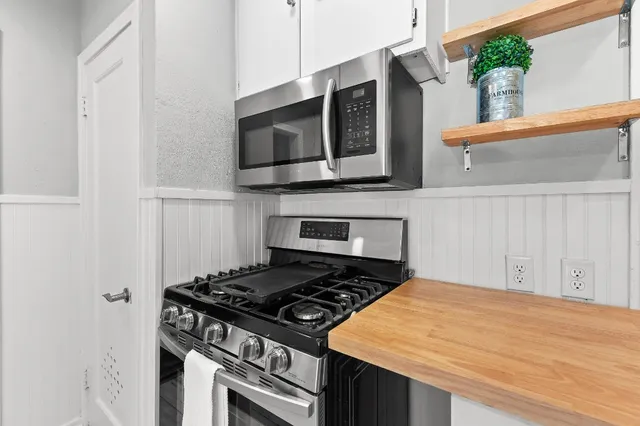 a kitchen with stainless steel appliances a stove and a microwave