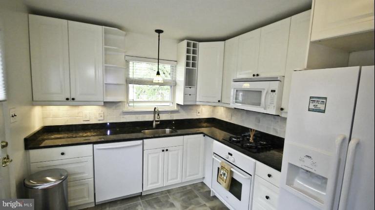 8245 Rupert Road South Millersville, MD 21108 - Photo 10 of 30 a kitchen with granite countertop white cabinets white appliances and sink